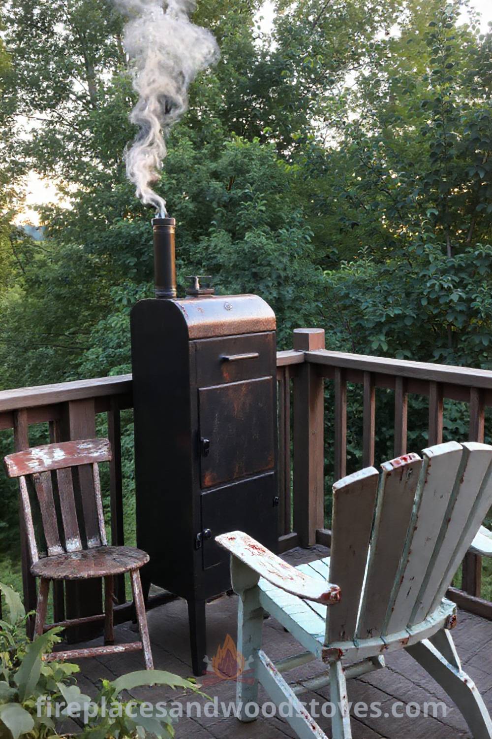 Vertical smoker barbecue on a wooden deck surrounded by greenery, with mismatched chairs and smoke rising from the chimney, creating a cozy outdoor space perfect for gatherings. Visit patioandhomefurniture.com for incredible outdoor design ideas.
