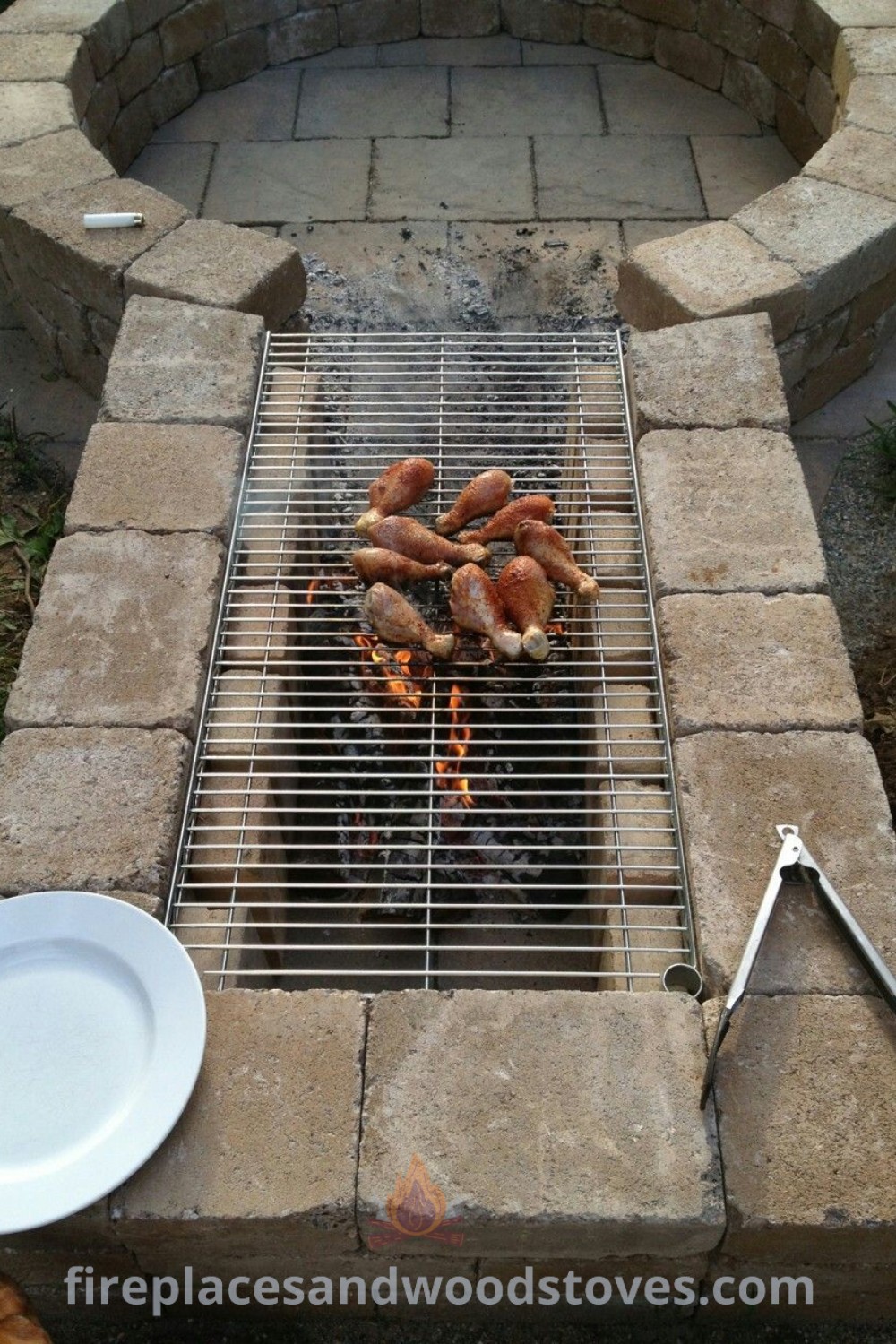 A grill with hot dogs cooking on it, surrounded by inviting backyard seating and a fire pit, creating a cozy outdoor dining atmosphere. Discover stylish backyard designs and entertaining ideas at patioandhomefurniture.com.