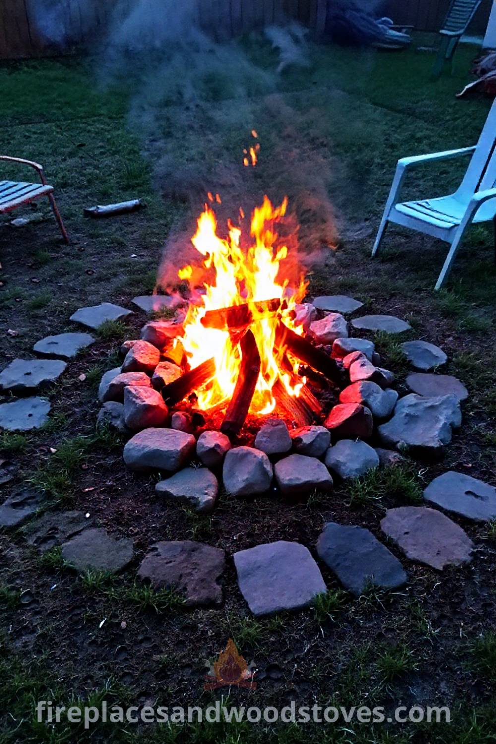 Backyard charcoal fire pit surrounded by worn stones and mismatched chairs, creating a cozy and inviting atmosphere for gatherings under the stars. Visit patioandhomefurniture.com for incredible outdoor design ideas transforming your backyard into a welcoming oasis.