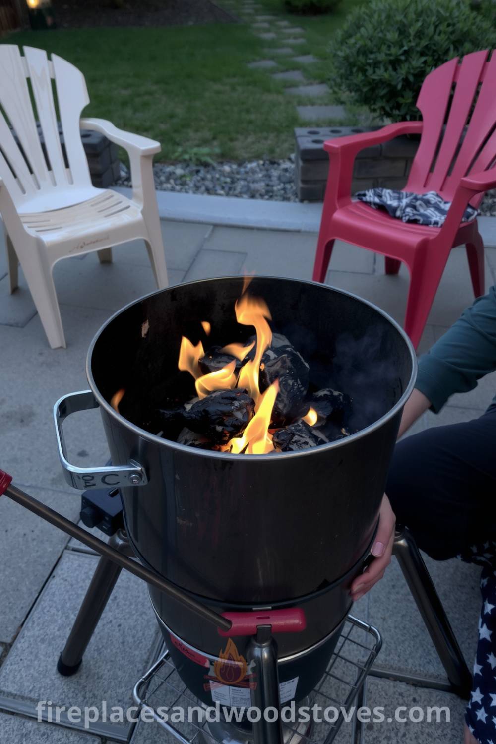 A cozy barbecue setup on a stone patio showcasing a metallic grill with signs of use, vibrant flames, and mismatched chairs, creating an inviting atmosphere perfect for gatherings and summer evenings, featured on fireplacesandwoodstoves.com.