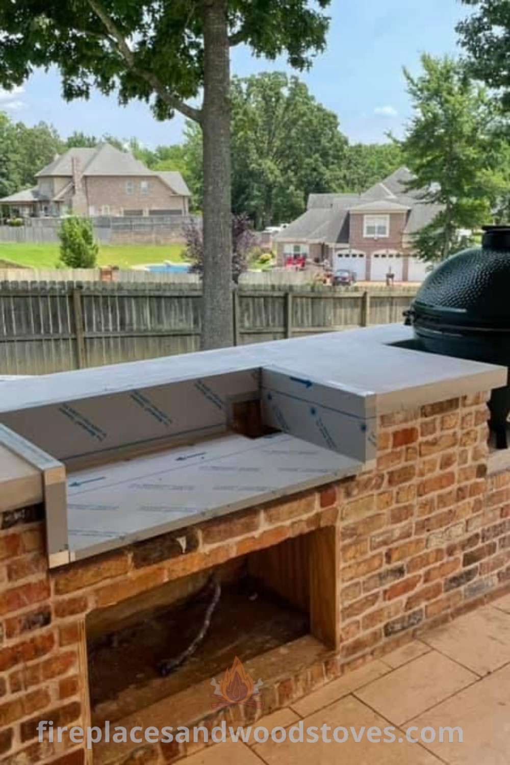 An outdoor barbeque area grill station built into a brick wall, featuring a large grill for cooking. This stylish design enhances your garden with vibrant decor and cozy seating options. Discover more outdoor kitchen ideas at patioandhomefurniture.com.