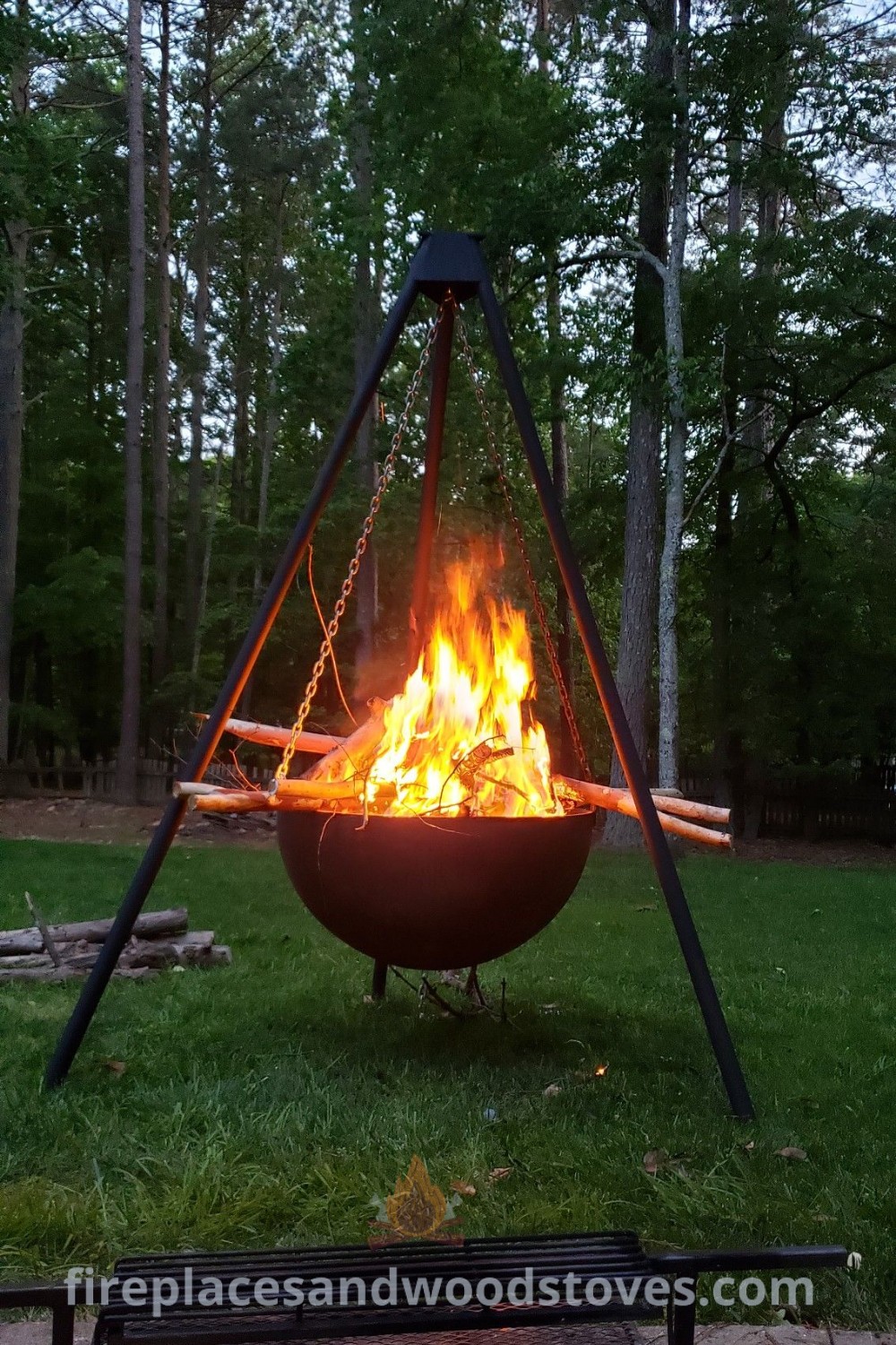 A tripod fire pit positioned on a lush green field, ideal for cozy outdoor gatherings. Enhance your patio with this stylish fire element, offering incredible ideas for transforming your space. Discover more about outdoor decor at patioandhomefurniture.com.