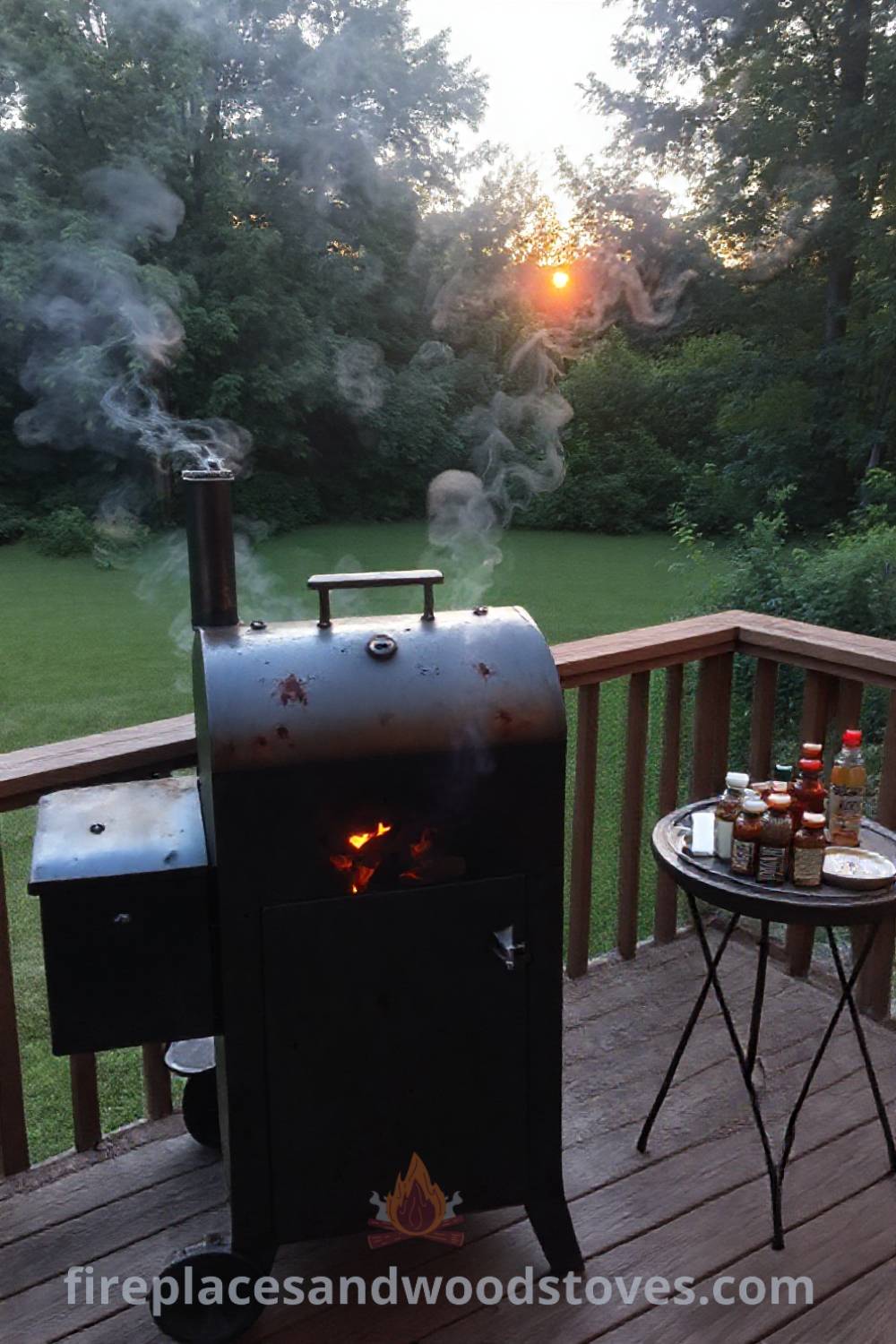 Sturdy barbecue smoker on a wooden deck surrounded by greenery, emitting smoke with a cozy atmosphere, complemented by a table of sauces and sides, creating an inviting outdoor space. Visit patioandhomefurniture.com for stylish ideas transforming your backyard.