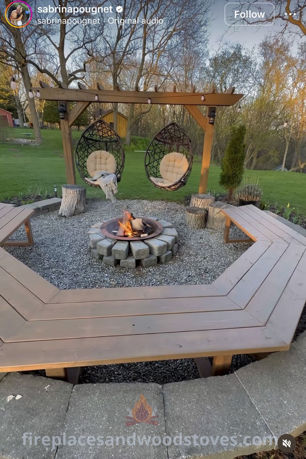 An outdoor fire pit surrounded by swings and chairs, complemented by beautiful flower beds, creating a cozy patio area ideal for gatherings. Discover stylish outdoor fire pit ideas at patioandhomefurniture.com.