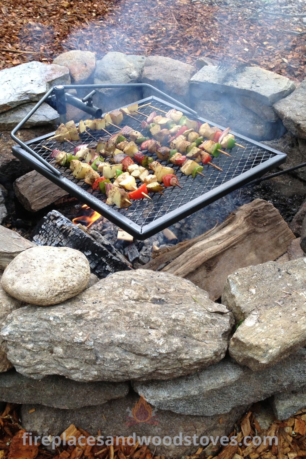An outdoor fire pit with rocks and skewers cooking food, enhancing backyard gatherings with aesthetic charm and functionality. Discover stylish outdoor decor ideas at patioandhomefurniture.com.
