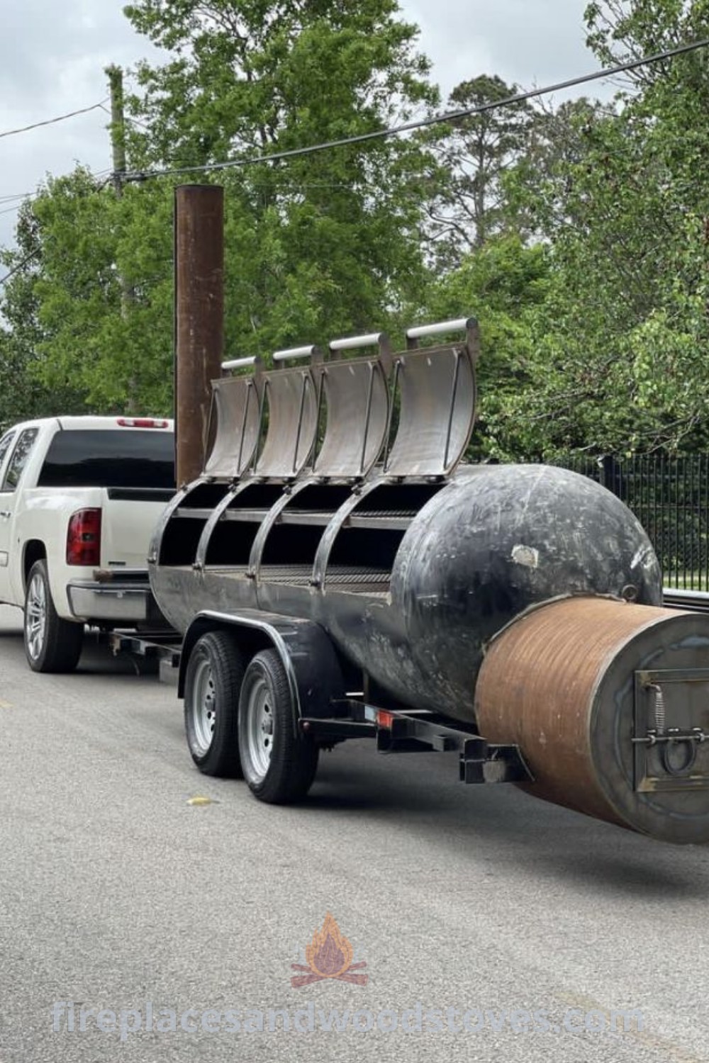 A truck carrying two large barrels on its flatbeds, showcasing a homemade smoker perfect for stylish outdoor BBQs. Discover functional designs and unique ideas that transform your backyard at patioandhomefurniture.com.