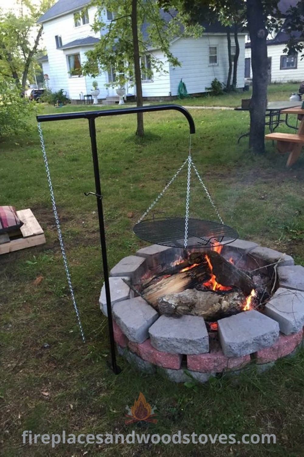 A cozy outdoor fire pit in the middle of a yard, surrounded by rustic seating, ideal for a charming backyard space. Explore outdoor fire pit designs and summer home decor ideas to enhance your outdoor experience at patioandhomefurniture.com.