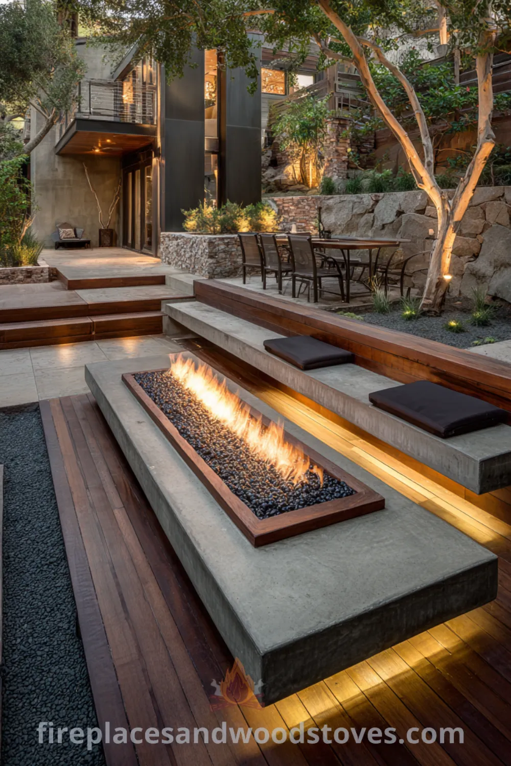 Chic modern luxury fire pit with polished concrete, exotic wood accents, and ambient LED lighting on a tiered wooden deck.