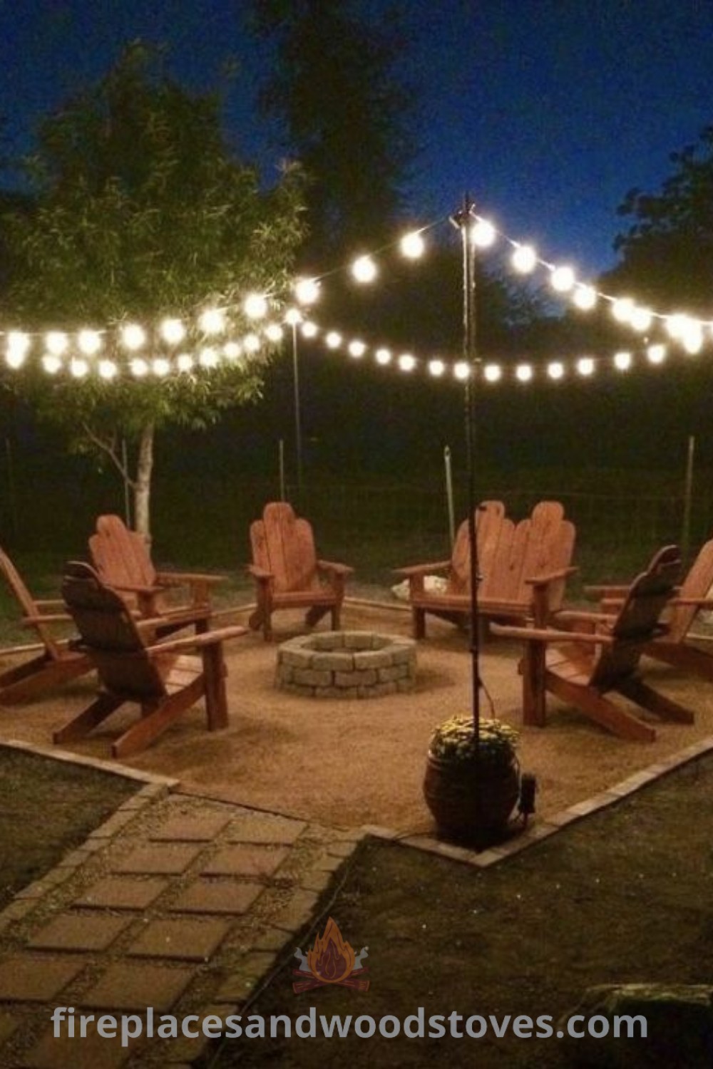 An outdoor fire pit surrounded by lawn chairs and string lights, creating a cozy atmosphere perfect for gatherings. This setup showcases rustic fire pit designs and enhances backyard aesthetic, ideal for outdoor entertaining. Explore more outdoor ideas at patioandhomefurniture.com.