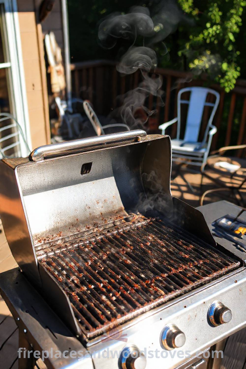 Outdoor BBQ grill on a wooden deck with a metallic surface reflecting sunlight, surrounded by mismatched patio furniture and wisps of smoke, creating a cozy and inviting atmosphere for gatherings. Visit patioandhomefurniture.com for stylish design ideas that will wow your guests.