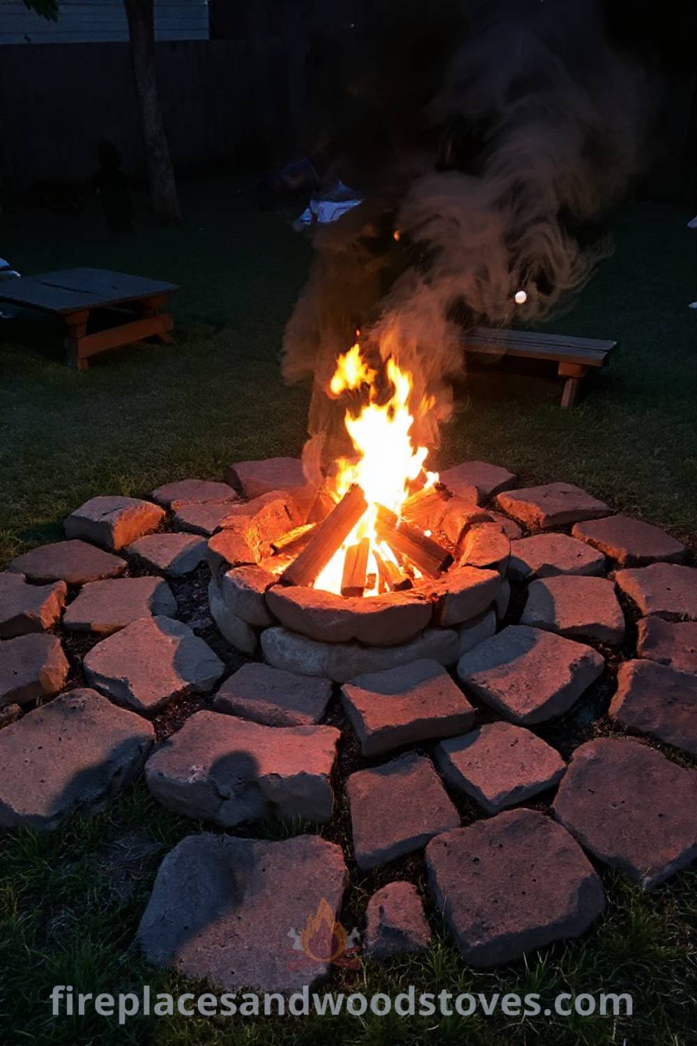Backyard camping scene featuring a wood-burning fire pit surrounded by uneven stones, warm flames illuminating children roasting marshmallows, creating a cozy atmosphere perfect for gatherings. Visit patioandhomefurniture.com for stylish outdoor design ideas that will wow your guests.