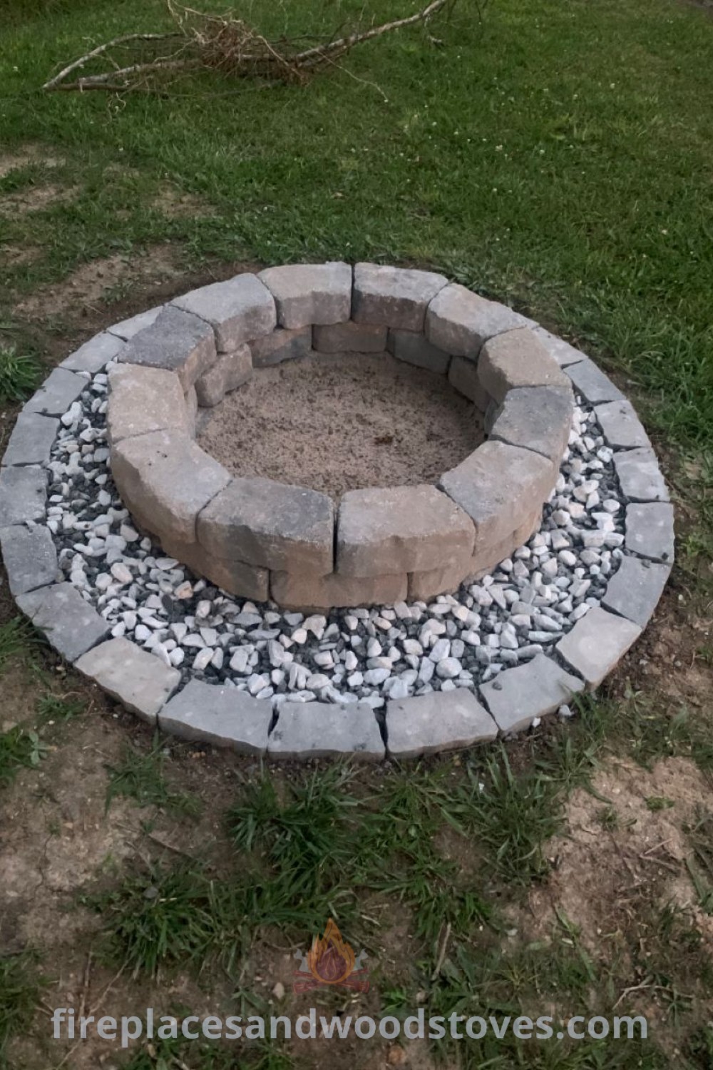 A stone fire pit in a grassy area, ideal for creating a cozy outdoor gathering space. Perfect for circle fire pit designs and DIY bonfire pit ideas. Explore more stylish outdoor fire pit concepts at patioandhomefurniture.com.