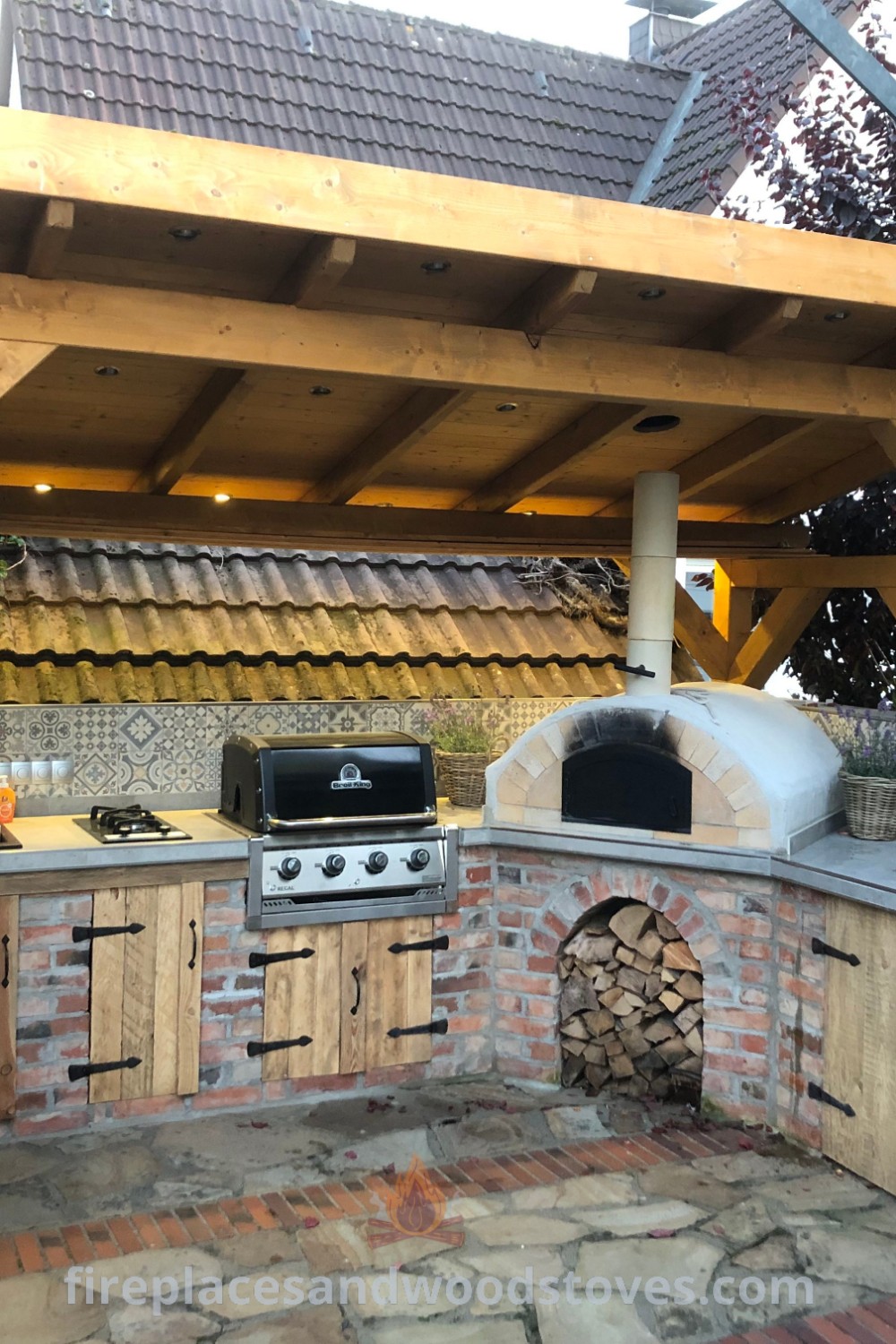 An outdoor kitchen integrated into a brick wall with wood detailing, featuring a BBQ area and pizza oven, offering stylish and functional outdoor cooking ideas for your backyard. Discover more inspiration and designs at patioandhomefurniture.com.
