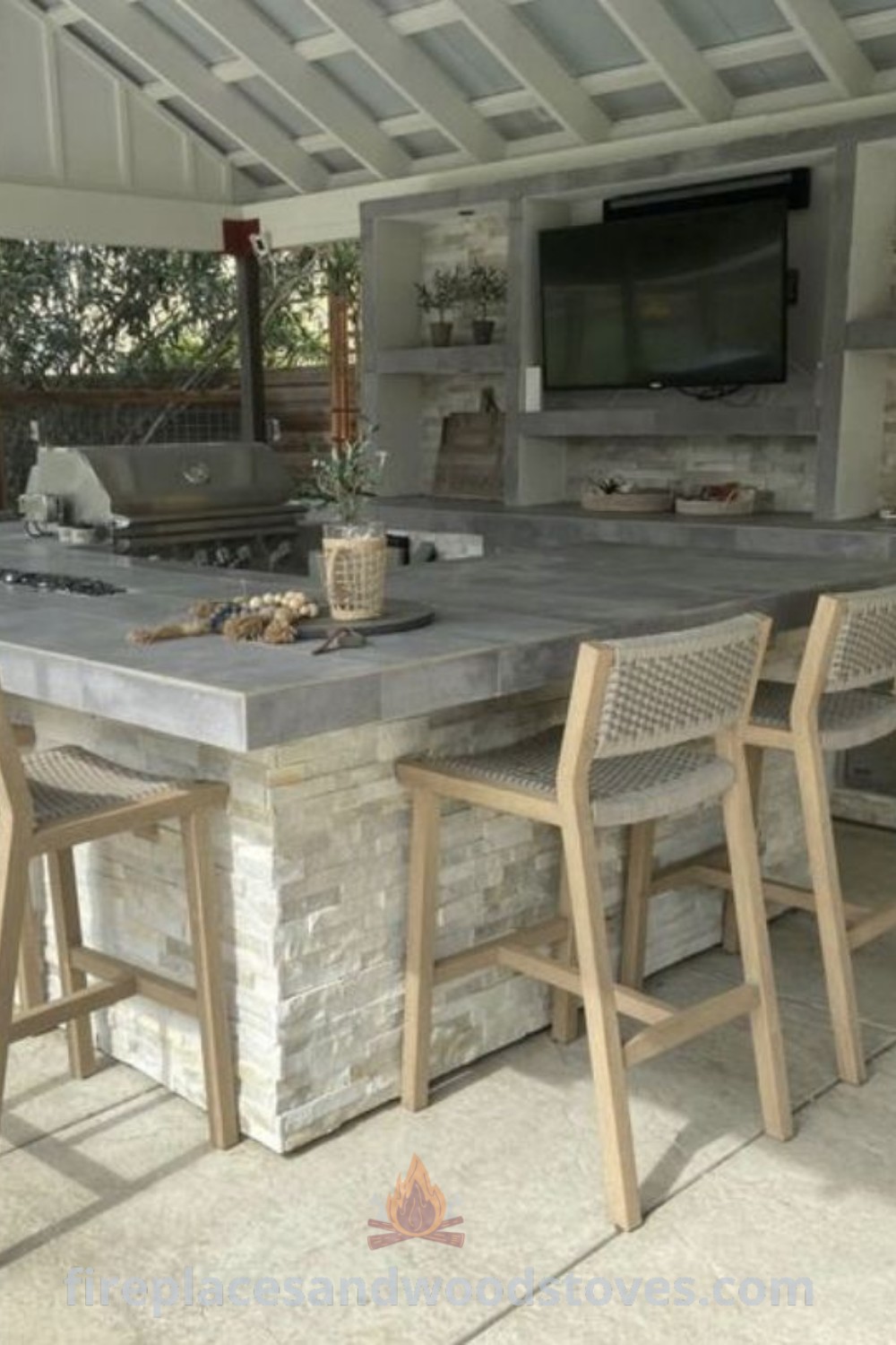 A covered outdoor kitchen with bar stools and a television, showcasing an inviting outdoor space ideal for BBQ gatherings and entertaining. Discover stylish outdoor kitchen designs and ideas you
