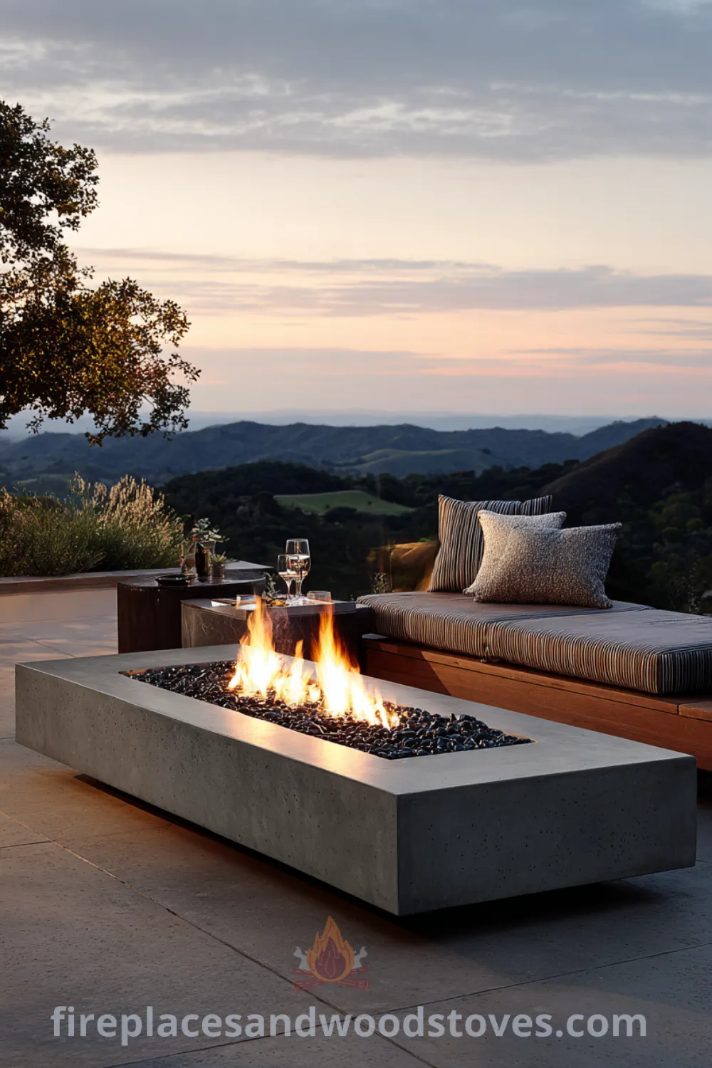 A modern fire pit table with smooth concrete and black lava rocks creates an elegant outdoor space for gatherings, featuring sleek designs and contemporary elements.