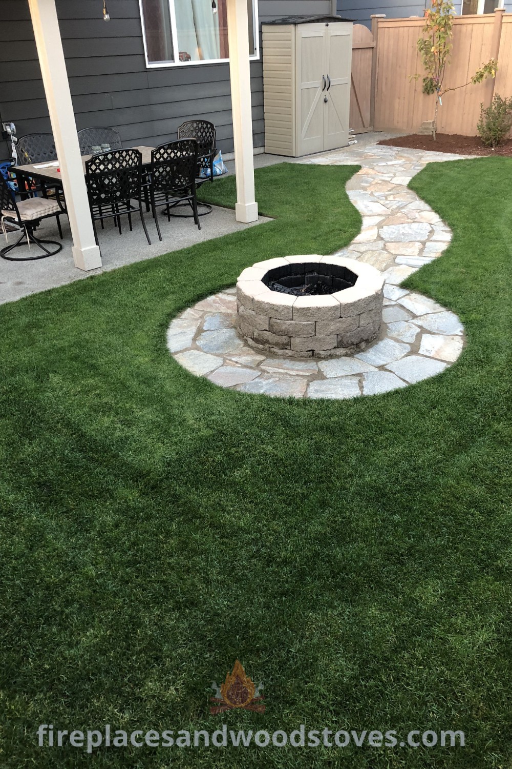A cozy backyard featuring a fire pit on turf surrounded by lush grass and seating areas, creating an inviting outdoor fire pit space. Discover incredible outdoor decor ideas and inspiration at patioandhomefurniture.com.