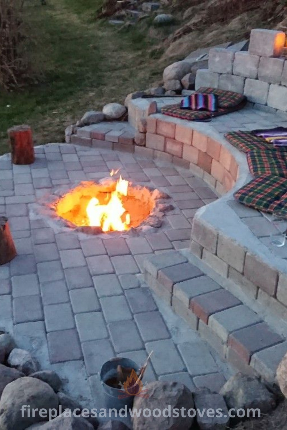 An outdoor fire pit area with cozy chairs and sloped backyard landscaping, perfect for creating a relaxing and stylish environment. Discover incredible outdoor fire pit designs at patioandhomefurniture.com.