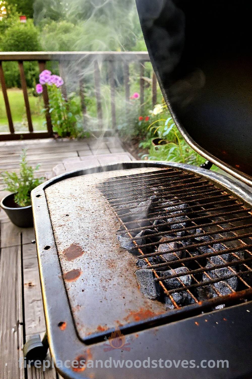 Classic charcoal grill barbecue on a weathered wooden deck with smoldering charcoal, smoke curling upwards, surrounded by garden plants, creating a cozy outdoor atmosphere perfect for gatherings. Visit patioandhomefurniture.com for incredible outdoor design inspiration.
