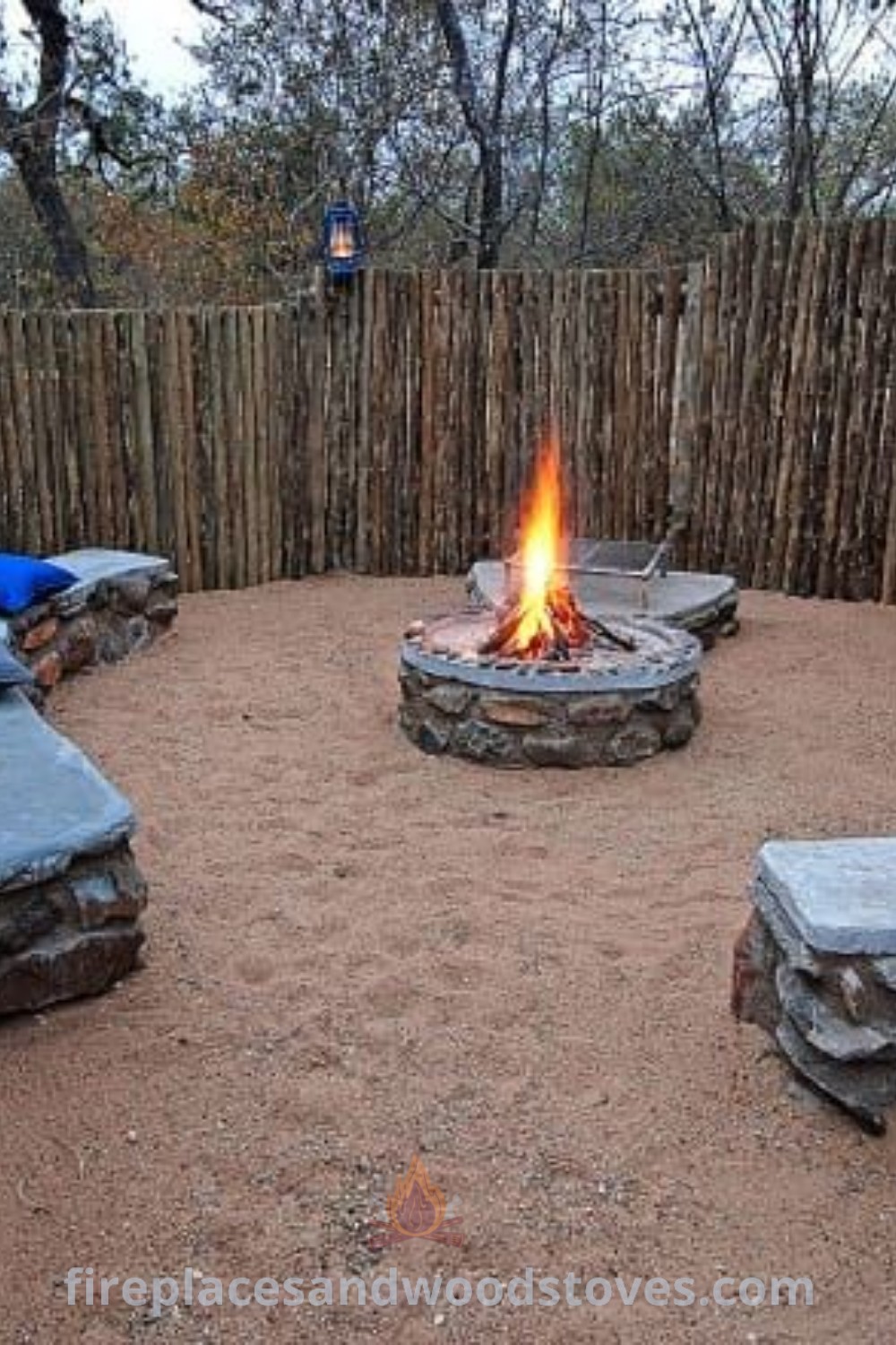 An outdoor fire pit with benches and pillows in front of a bamboo fence, showcasing stylish boma seating ideas for a cozy atmosphere. Perfect for enhancing backyard grills and entertaining guests. Discover more outdoor inspiration at patioandhomefurniture.com.