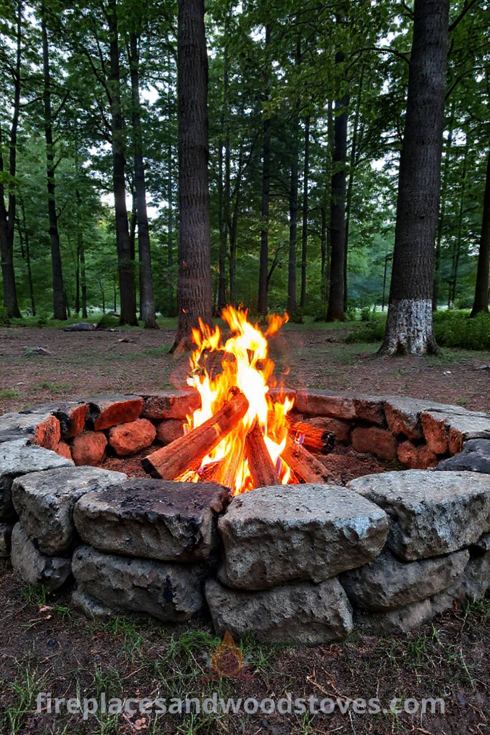 Rustic camping fire pit in a secluded clearing surrounded by tall trees, featuring a cozy seating arrangement with logs, creating an inviting atmosphere for outdoor gatherings. Visit patioandhomefurniture.com for incredible ideas transforming your backyard.