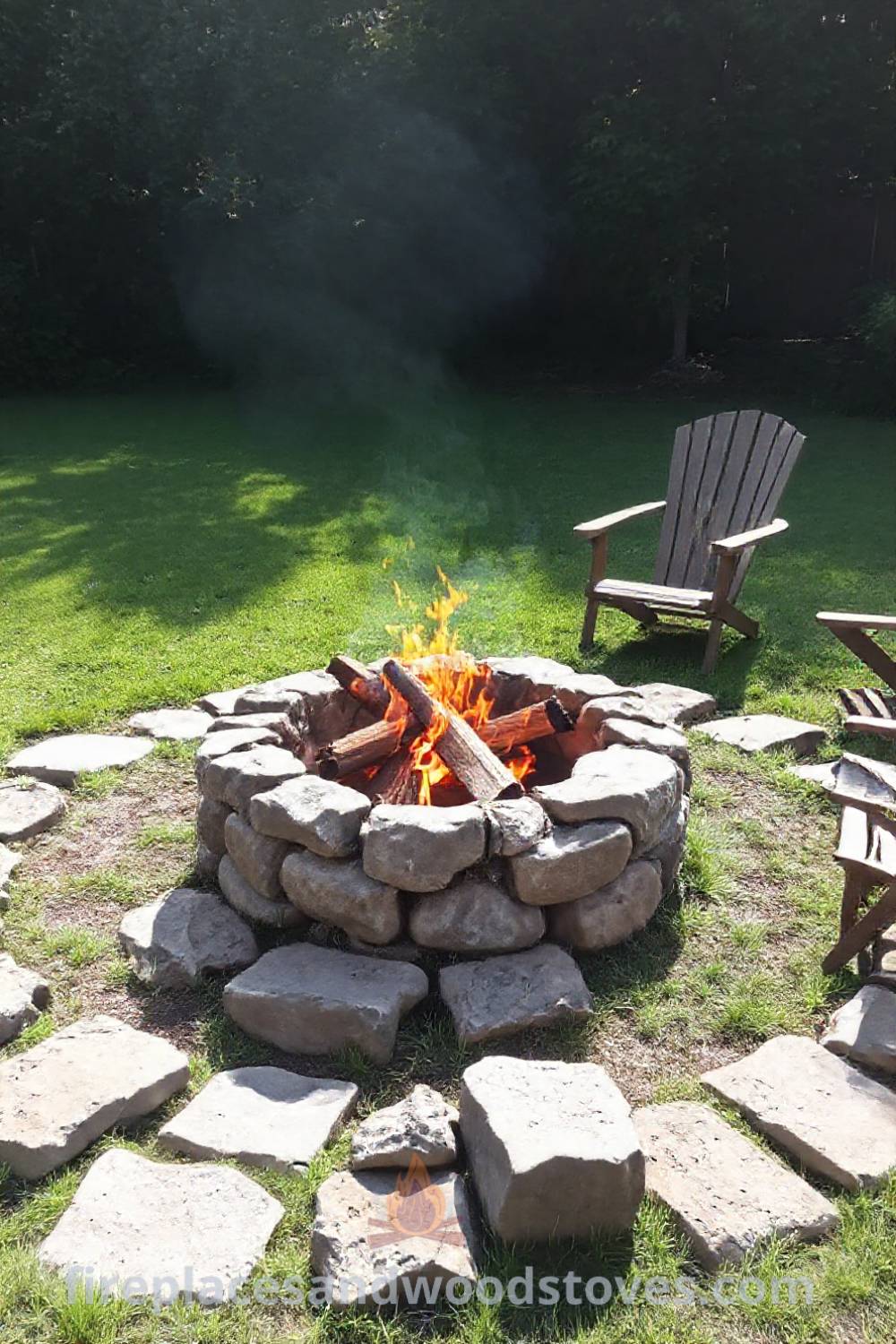 Traditional stone wood-burning fire pit surrounded by rugged stones and wooden chairs in a sun-dappled yard, creating an inviting atmosphere for gatherings with friends and family, perfect for cozy outdoor inspiration. Visit patioandhomefurniture.com for incredible ideas that will wow your guests.