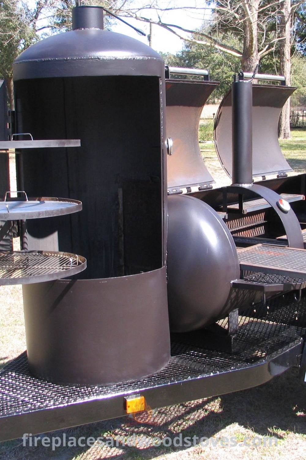 An outdoor wood fired stove on a trailer in grass by trees, showcasing stylish smoker designs for backyard gatherings. Enjoy creative BBQ trailer ideas and build custom smokers that enhance your outdoor space. Discover more outdoor inspiration at patioandhomefurniture.com.