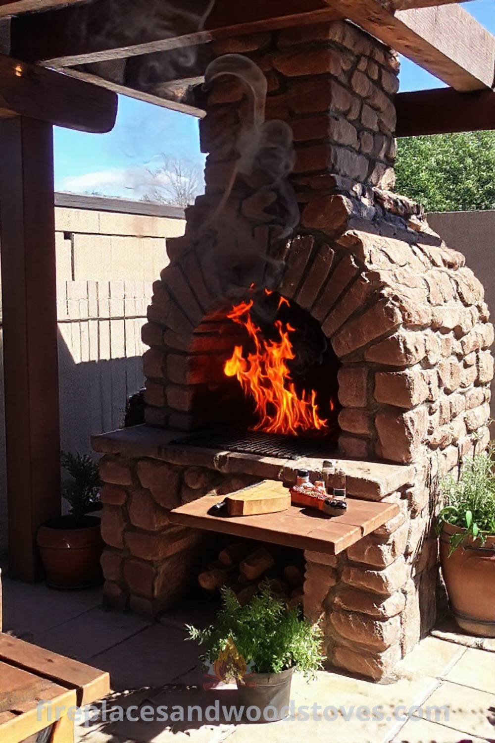 Sturdy stone BBQ oven on a sun-drenched patio with flames, wooden grill tools, and potted herbs, perfect for enhancing outdoor cooking experiences. Visit patioandhomefurniture.com for stylish outdoor ideas you
