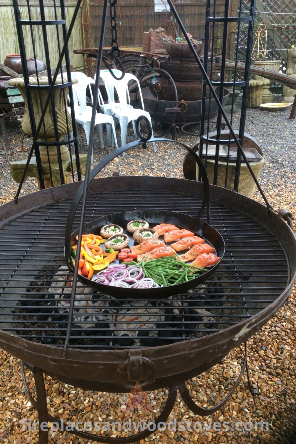 An outdoor grill with various foods cooking, including a BBQ grill smoker and a beautiful pizza oven, enhancing backyard gatherings. Discover stylish and functional designs for your outdoor space at patioandhomefurniture.com.
