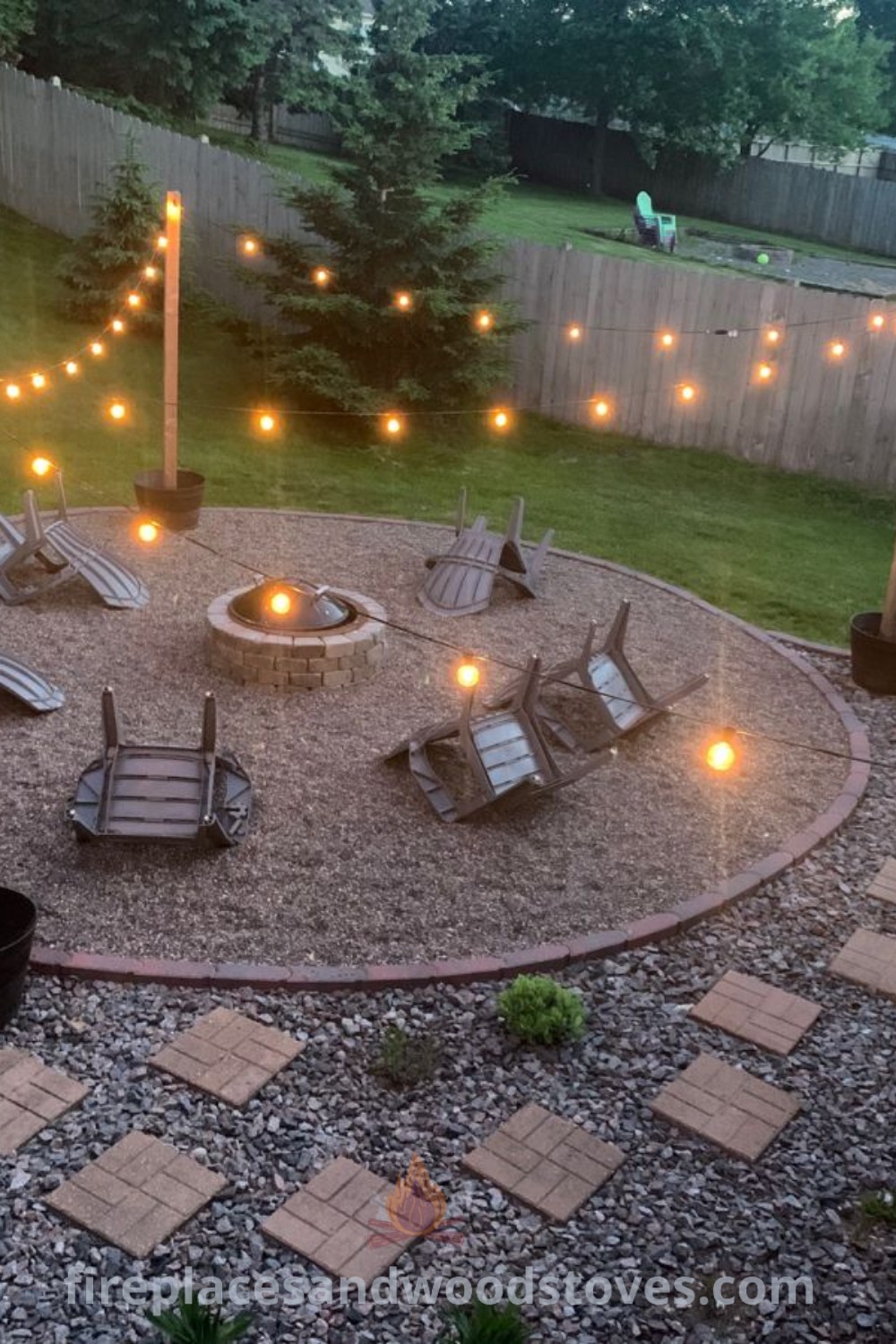 A stunning backyard fire pit area with cozy lawn chairs, string lights, and gravel walkways, ideal for outdoor gatherings. Discover stylish and affordable backyard ideas at patioandhomefurniture.com.