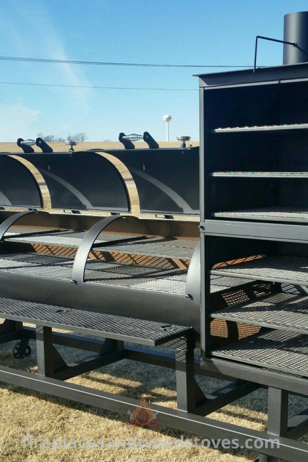 A large black smoker grill positioned on a dry grass field, showcasing stylish smoker grill designs ideal for backyard BBQs, custom smokers, and BBQ business inspiration. Explore incredible ideas for your outdoor cooking at patioandhomefurniture.com.