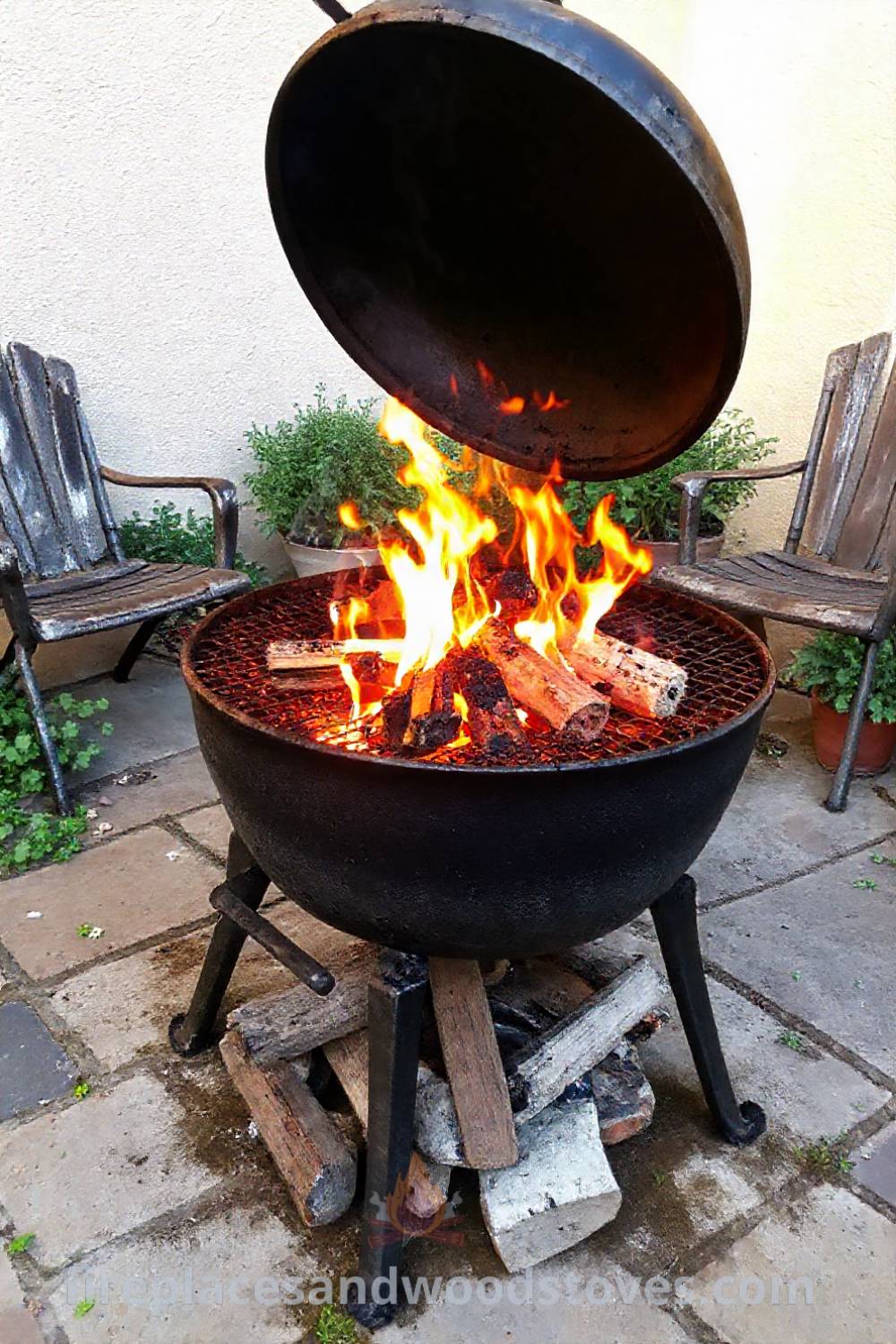 Cozy wood-fired barbecue on a stone patio, surrounded by faded outdoor chairs and pots of herbs, creating an inviting atmosphere for summer gatherings. Visit patioandhomefurniture.com for stylish ideas that will wow your guests and transform your backyard.