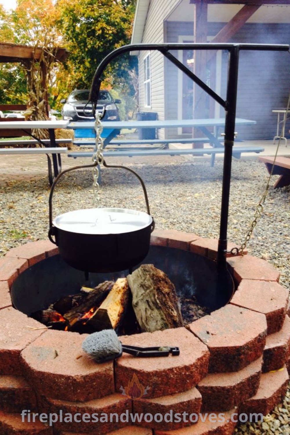 An open fire pit surrounded by swings on a gravel field, showcasing outdoor fire pit ideas that combine functionality and style. Enhance your backyard with a cozy atmosphere ideal for gatherings and entertaining. Discover more at patioandhomefurniture.com.