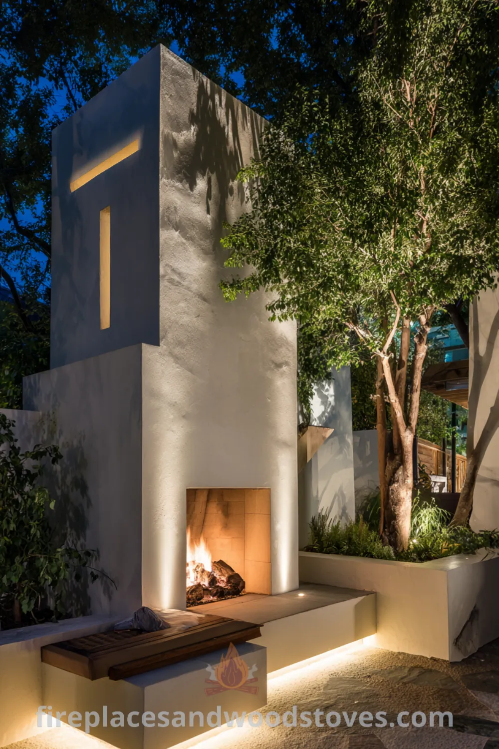 Modern minimalist outdoor fireplace with white stucco, integrated LED strips, and lush greenery for a serene environment.