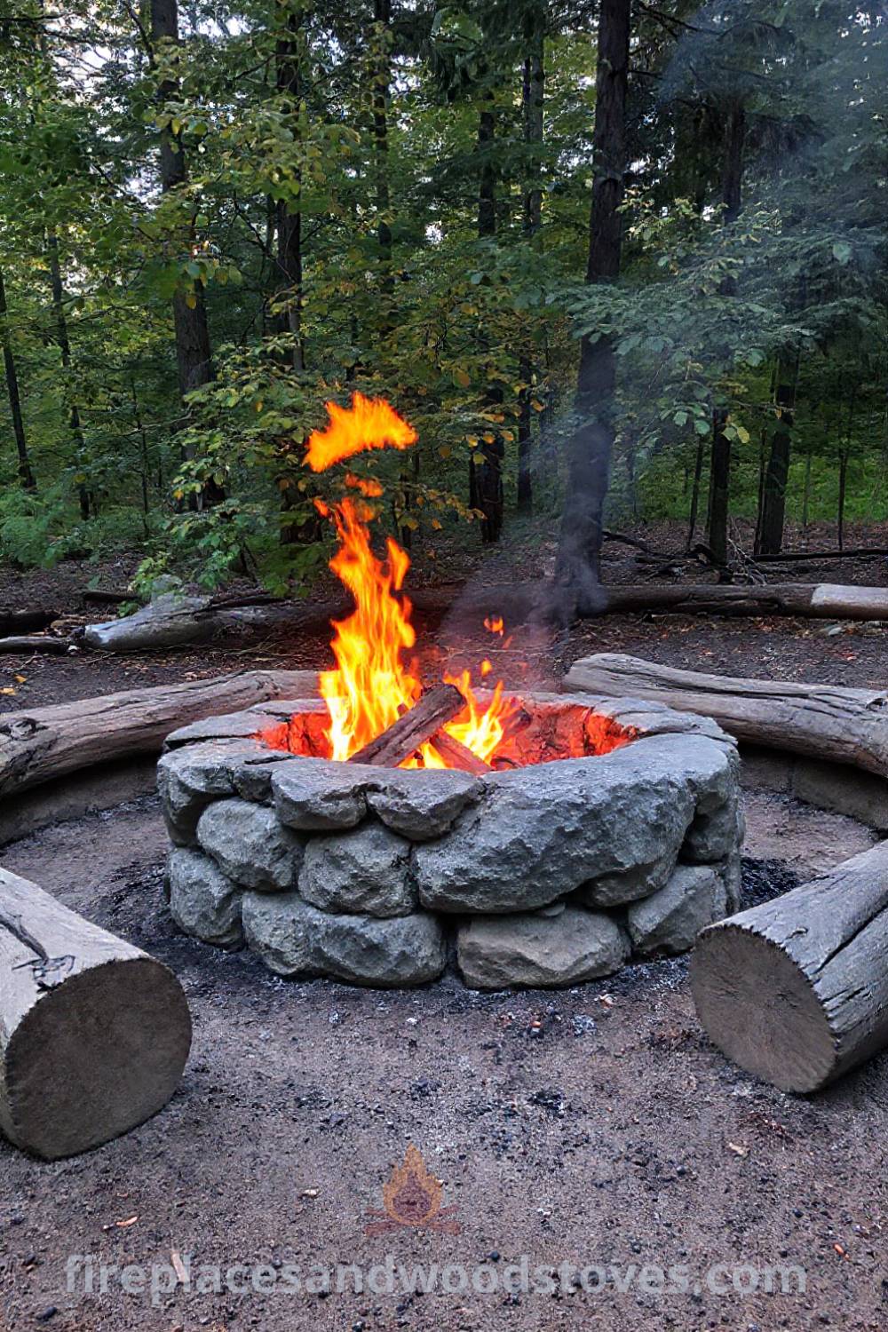 Rugged stone camping fire pit surrounded by worn wooden logs under trees, creating a cozy gathering space that invites warmth and connection, ideal for outdoor memories. Visit patioandhomefurniture.com for stylish designs that will wow your guests.