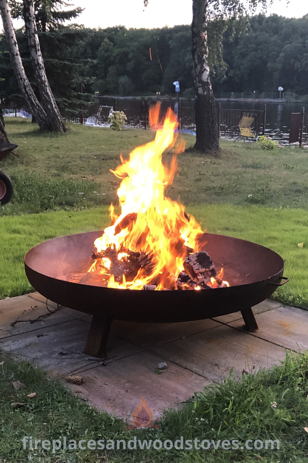 A fire pit situated on a wooden platform in the middle of a field, ideal for cozy gatherings in garden sitting areas. This stylish design enhances your outdoor patio and backyard, providing incredible ideas for outdoor living. Explore more at patioandhomefurniture.com.