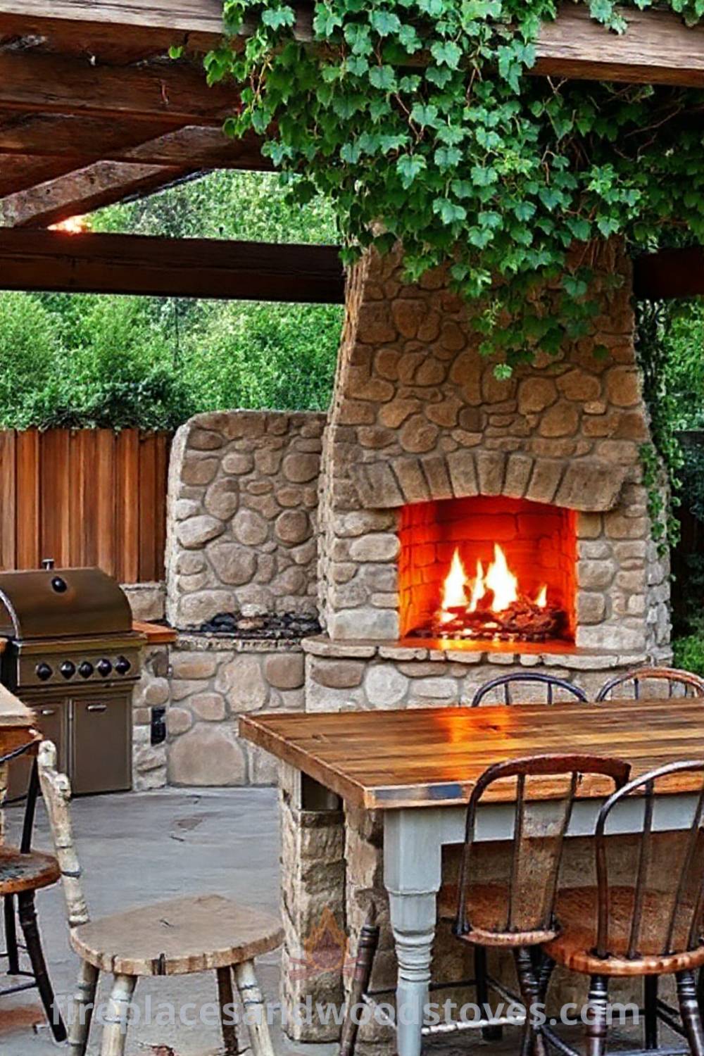 Outdoor kitchen with a stone wood-burning fireplace and rustic pergola, surrounded by climbing vines and reclaimed wood countertops, creating a cozy atmosphere for family gatherings. Visit patioandhomefurniture.com for stylish design ideas that will wow your guests.