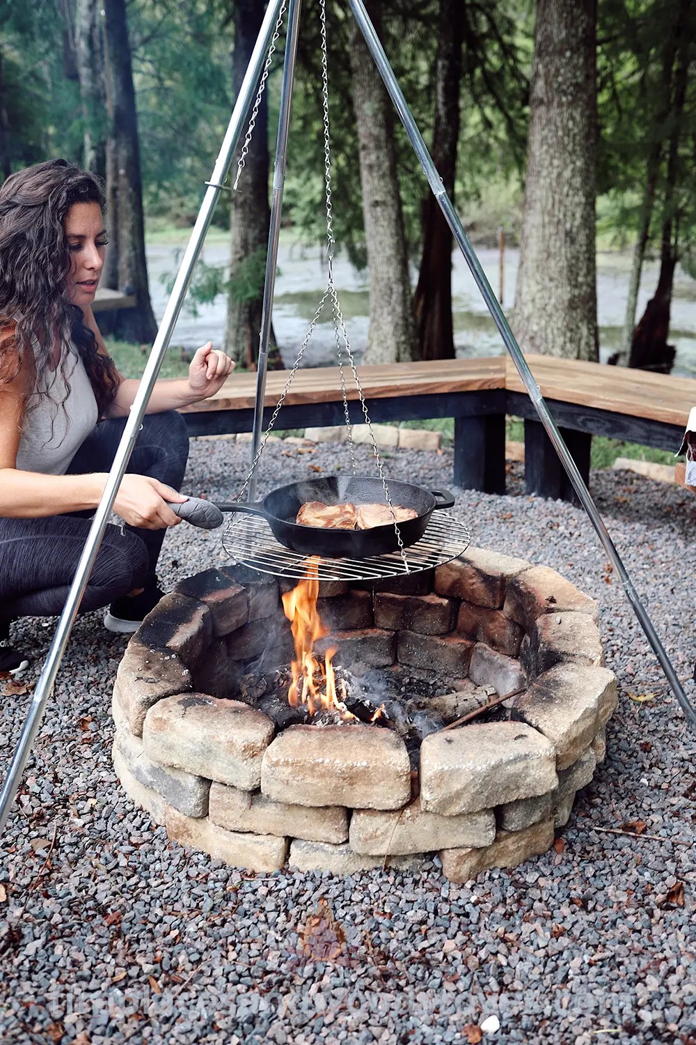 A woman enjoying a cozy evening in front of an open fire pit, creating a warm and inviting outdoor atmosphere. Enhance your backyard with stylish furniture and designs that transform your space. Discover more cozy outdoor ideas at patioandhomefurniture.com.