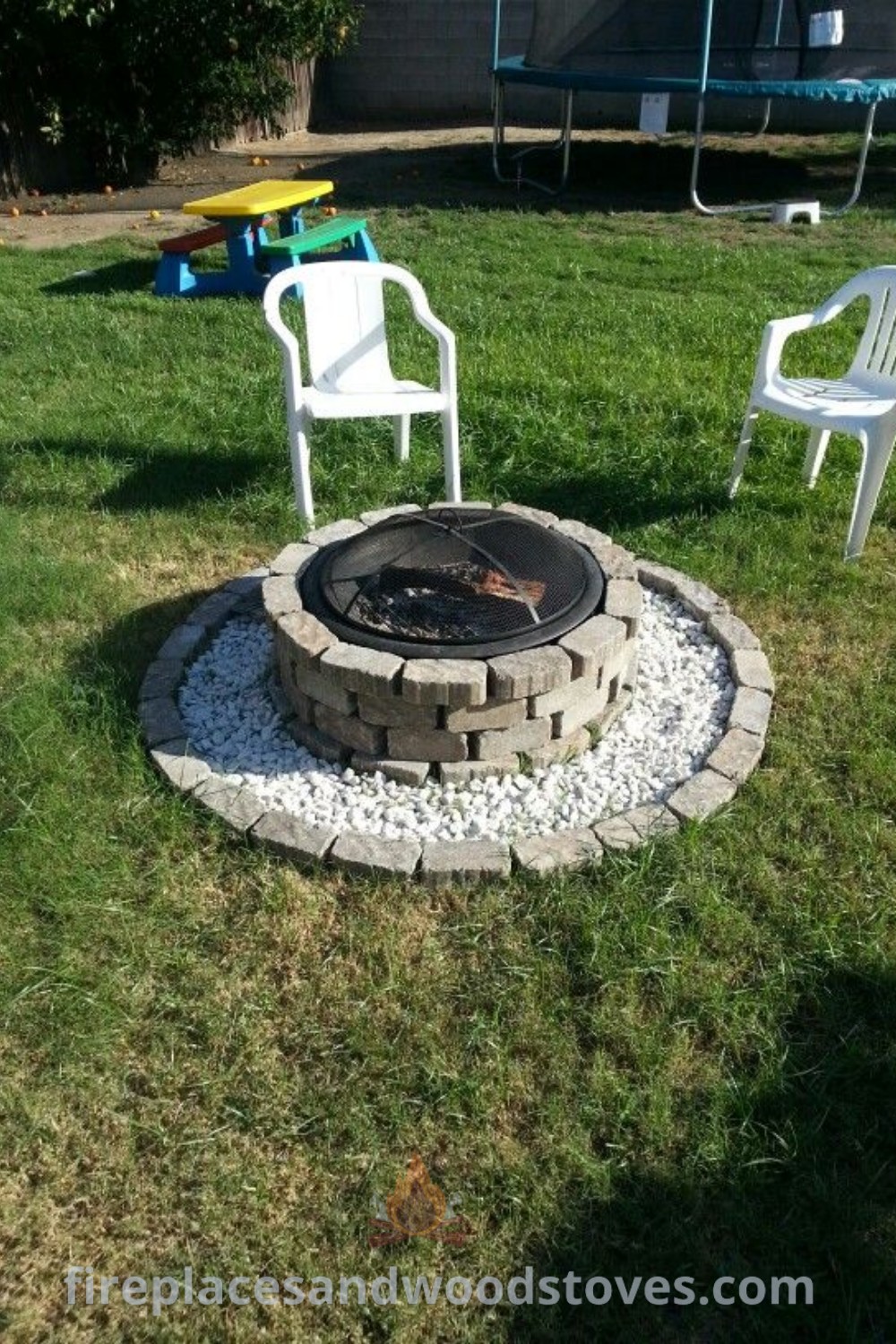 A beautifully designed fire pit surrounded by chairs and a table on a lawn, showcasing diy small fire pit ideas and simple backyard fire pit concepts. Create an inviting outdoor space with stylish designs transforming your backyard. Discover more incredible outdoor ideas at patioandhomefurniture.com.