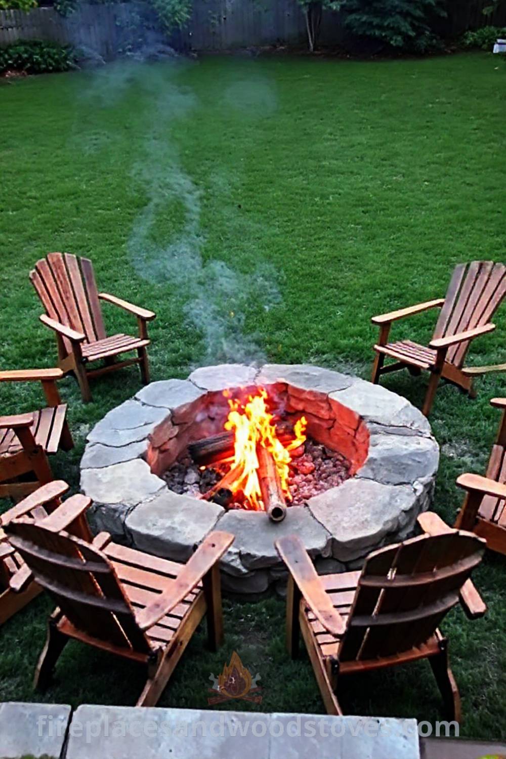 Cozy stone fire pit with flames illuminating mismatched wooden chairs, creating a warm atmosphere for evening gatherings in a backyard, perfect for conversation under the stars. Visit patioandhomefurniture.com for incredible outdoor design inspiration.