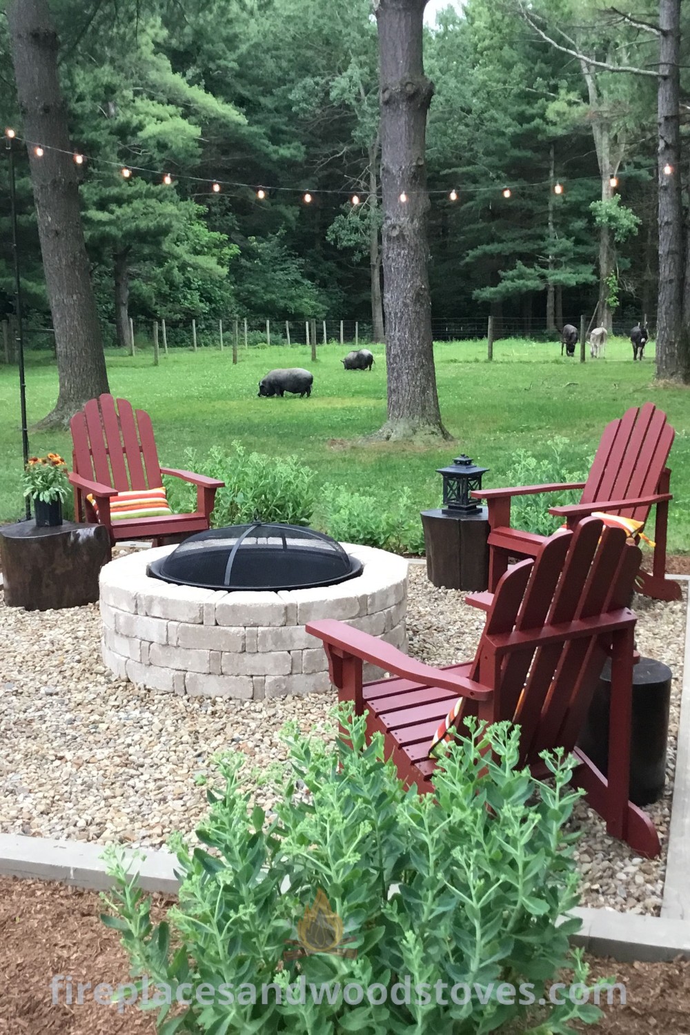 A cozy fire pit area surrounded by lawn chairs and string lights, featuring grass, trees, and bushes. Ideal for stylish backyard fire pit ideas and enhancing outdoor gatherings. Discover more designs that transform your space at patioandhomefurniture.com.